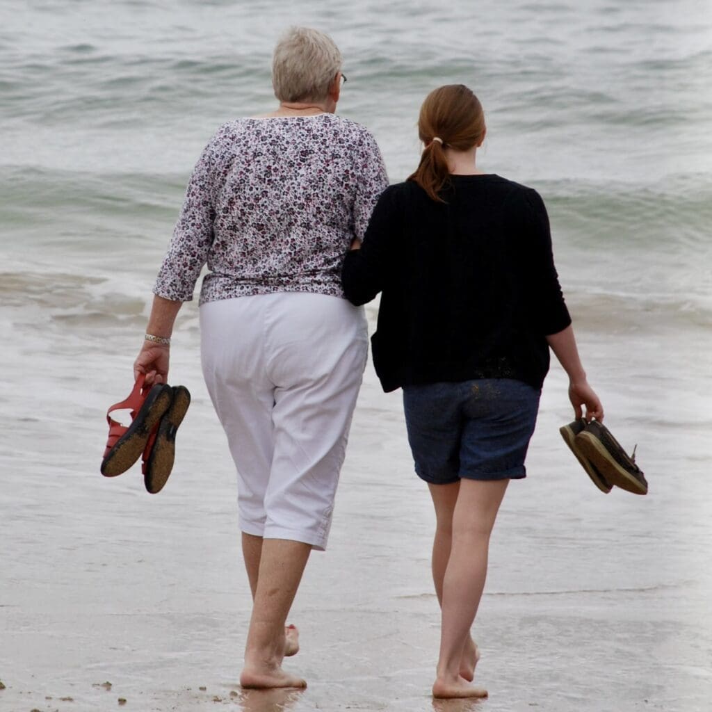 Two women walking in Acadia on the beach
