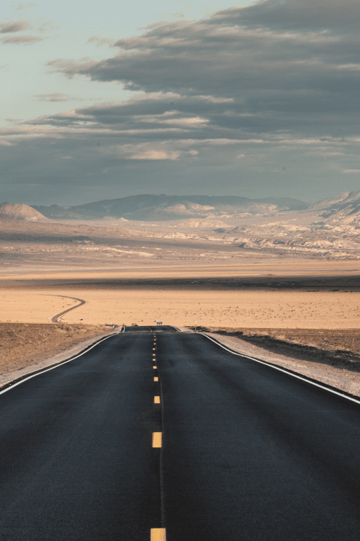 a roadway going into death valley national park with beautiful sunset
