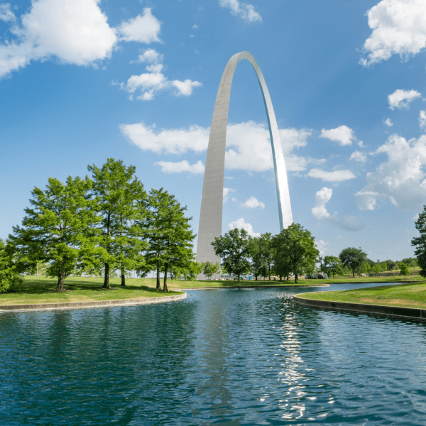 The St Louis Gateway Arch in Missouri with the lake in front and the reflection in the water.