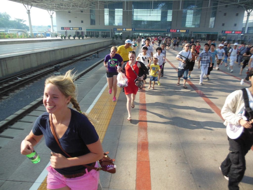American tourists including college age girls running with locals in Beijing to get on the train