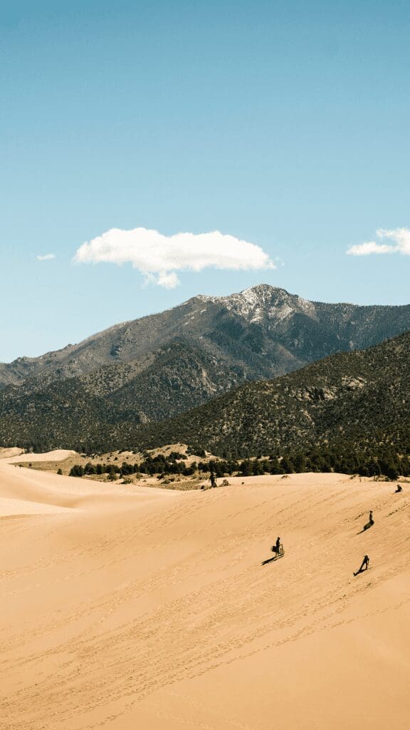 view of great sand dunes with mountains in distance