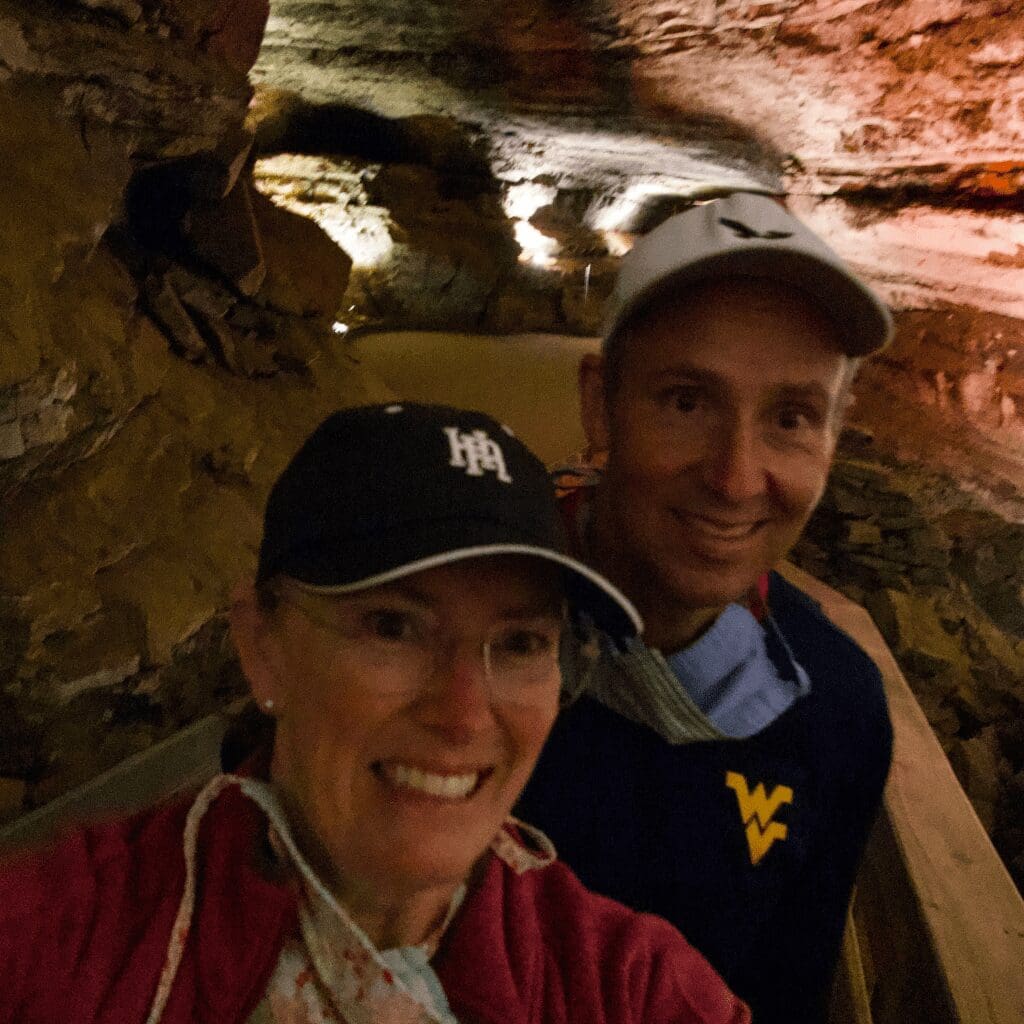 A man and a woman walking in a large cave