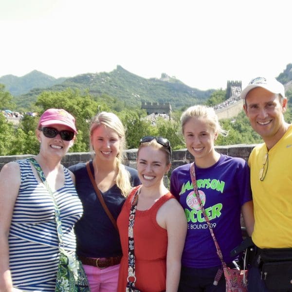 five people posing at great wall looking happy on a sunny day