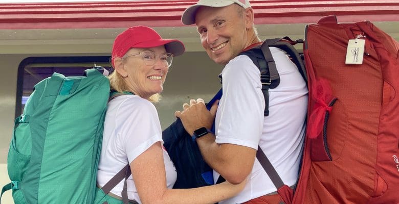 Woman and man standing with backpacks at train station