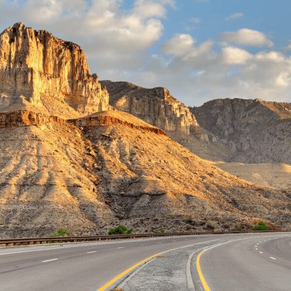 highway leading to Guadalupe mountains in Texas with mountains on side