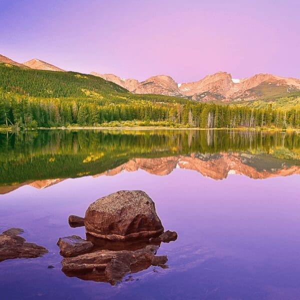 purple sky reflected in a lake a the park with mountains in the background of Rocky Mountain National Park