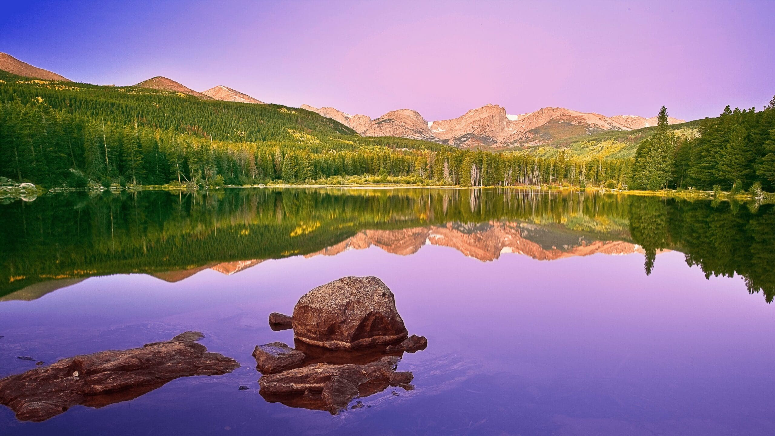 purple sky reflected in a lake a the park with mountains in the background