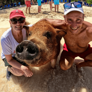 man and woman with a swimming pig in the Bahamas
