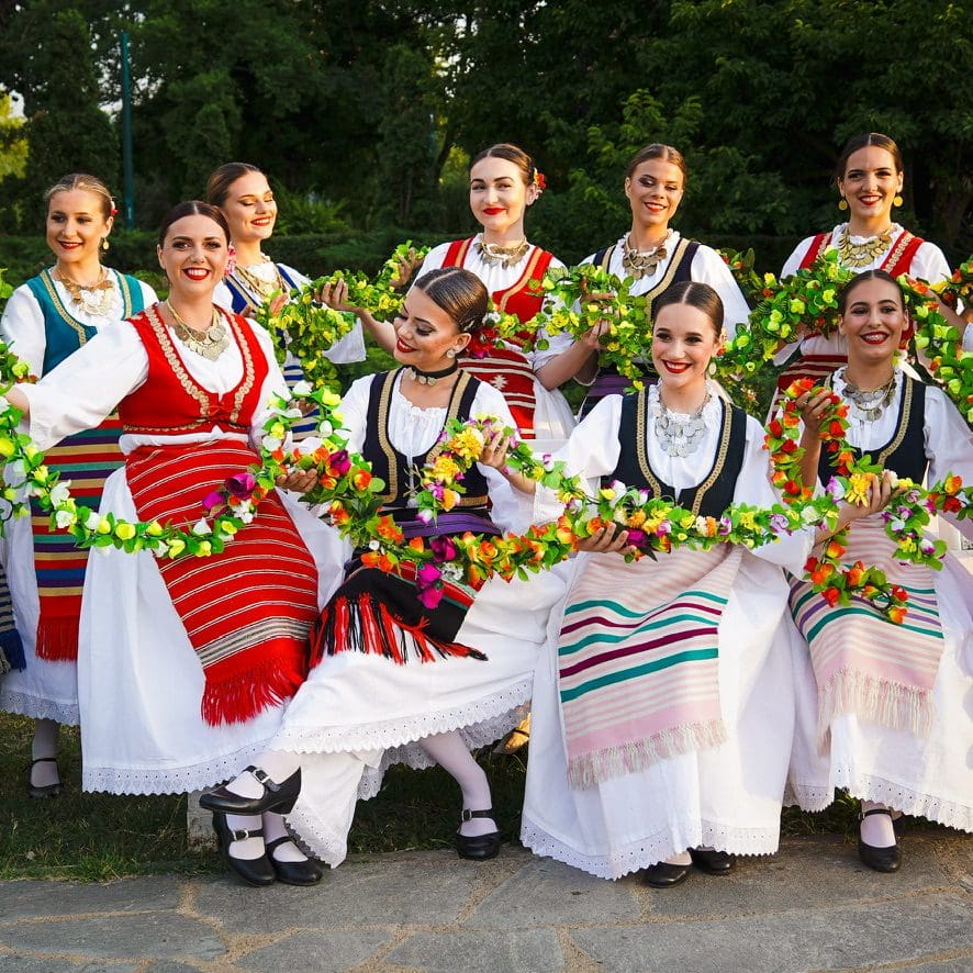 girls in traditional dress with flowers in hands