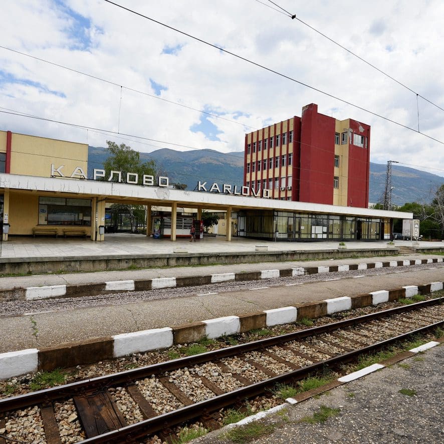 a station with tracks and bulgarian signage