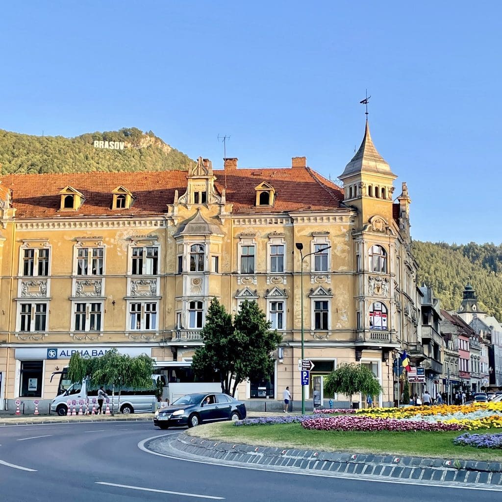 Brasov traffic circle with beautiful building and Brasov sign on hill