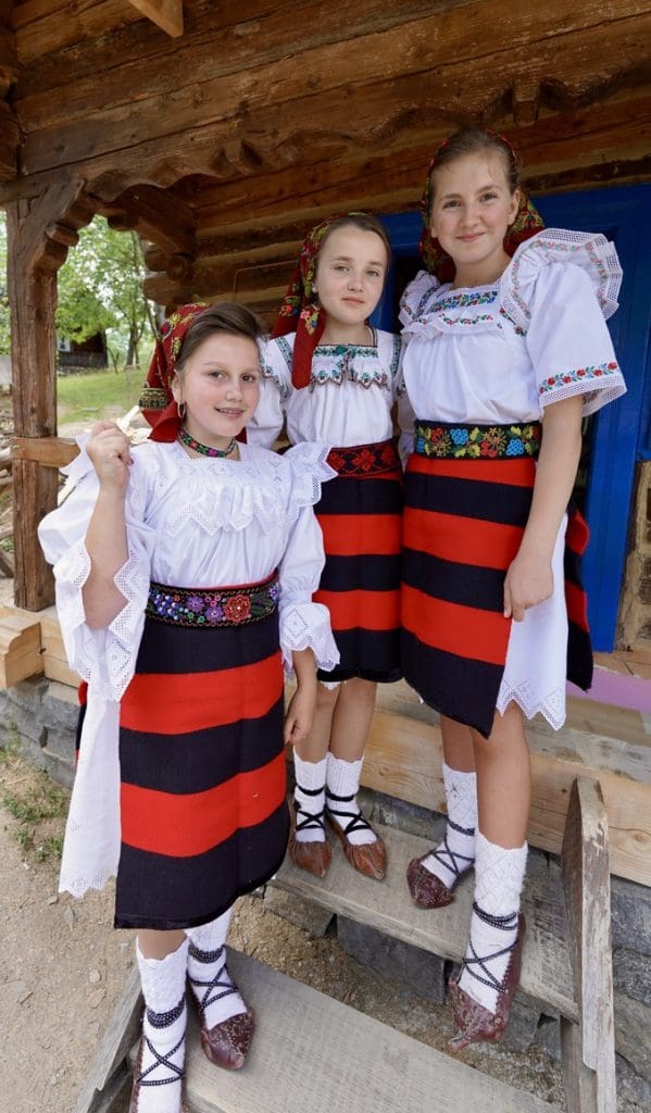 three girls dressed up in traditional romanian costumes