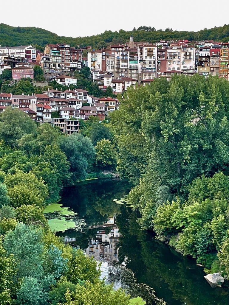 a tree lined river with Bulgarian city in distance