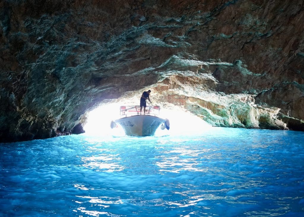 a boat entering a blue cave