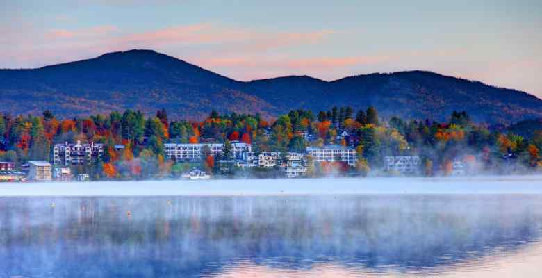 view of Lake Placid from a foggy lake with mountains in the background