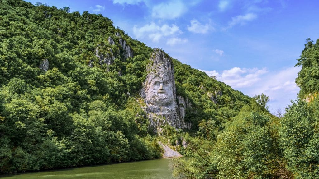 Sculpture in mountain of face overlooking river