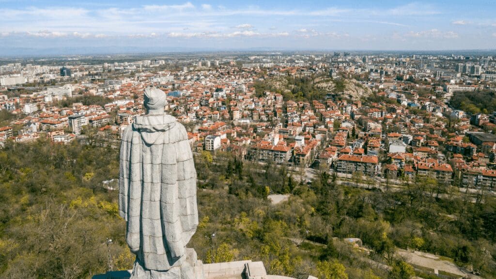a statue on a hill overlooking city