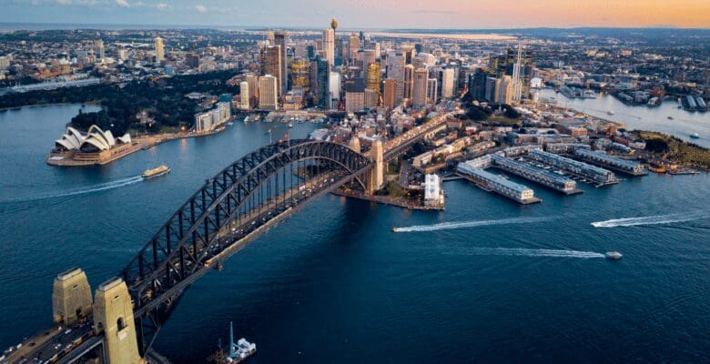 An aerial view of Sydney, Australia, and the Sydney Opera House surrounded by the Pacific Ocean.