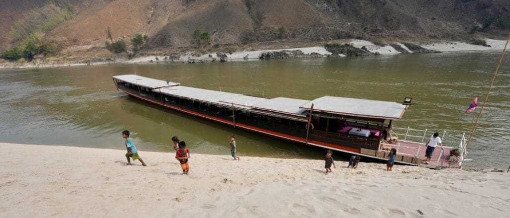 long boat on stopping near shore on Mekong River in Laos