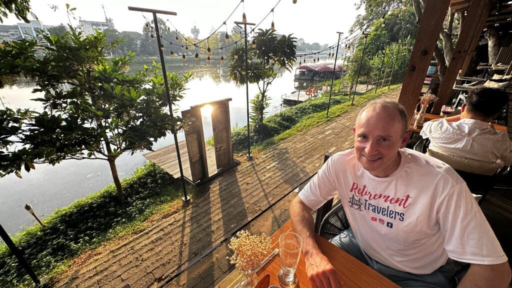 man sitting in a restaurant along a river