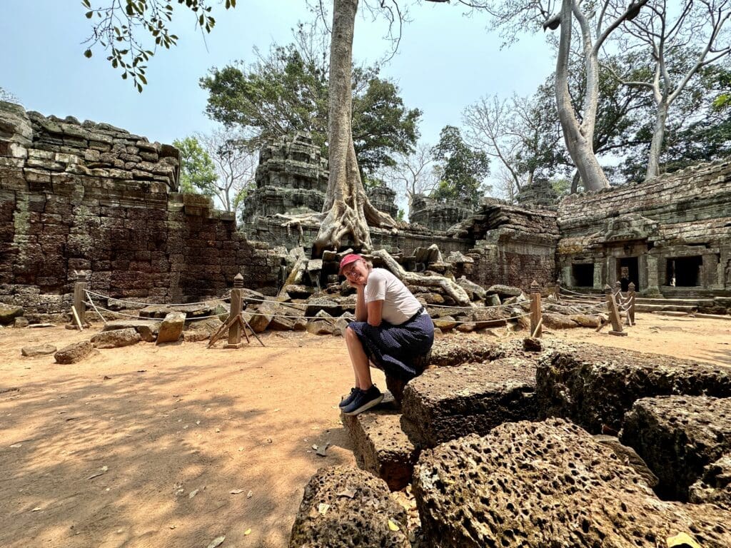 woman sitting in area of ancient ruins in Cambodia