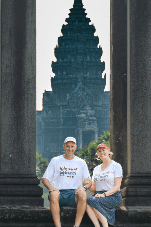 Retirement Travelers sitting in front of Angkor Wat temples in Cambodia