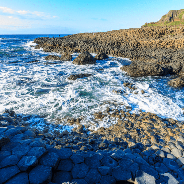 rugged shoreline with crashing waves and and unique, tubular rock formations