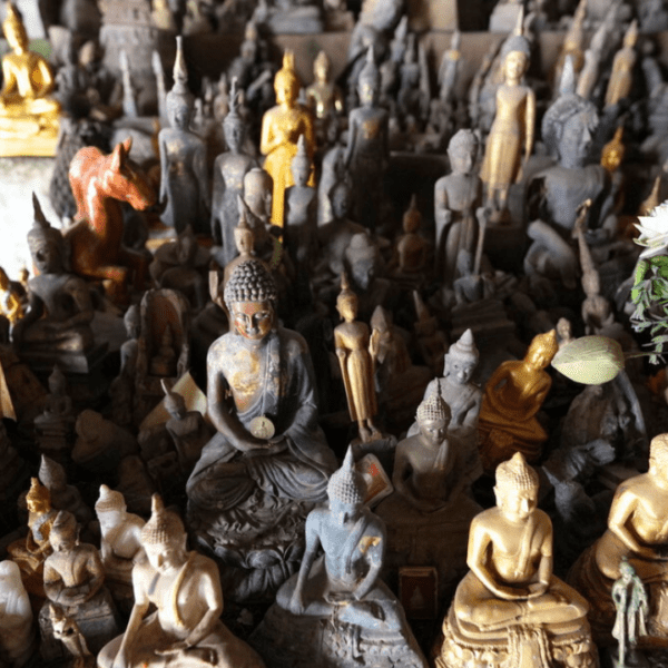 Many different Buddha statues of all sizes in a cave in Laos