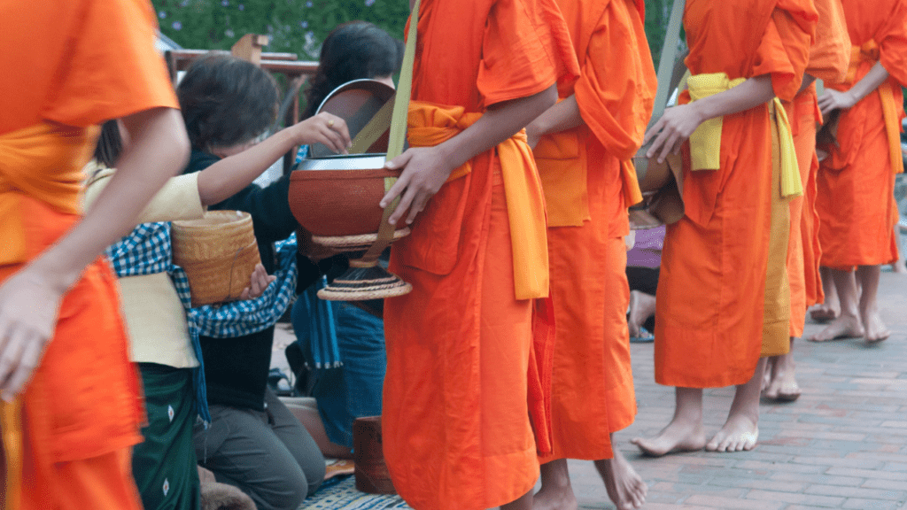 donations being given to monks wearing orange robes