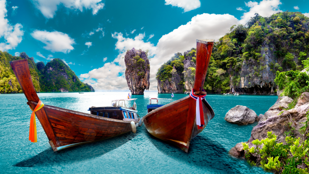 two boats in turquoise water with large rock formations coming out of water