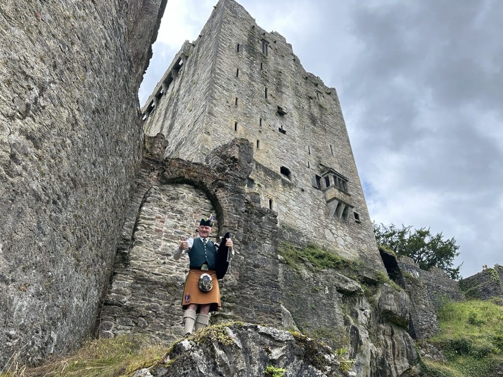 Man playing bagpipes outside Blarney Castle in Ireland