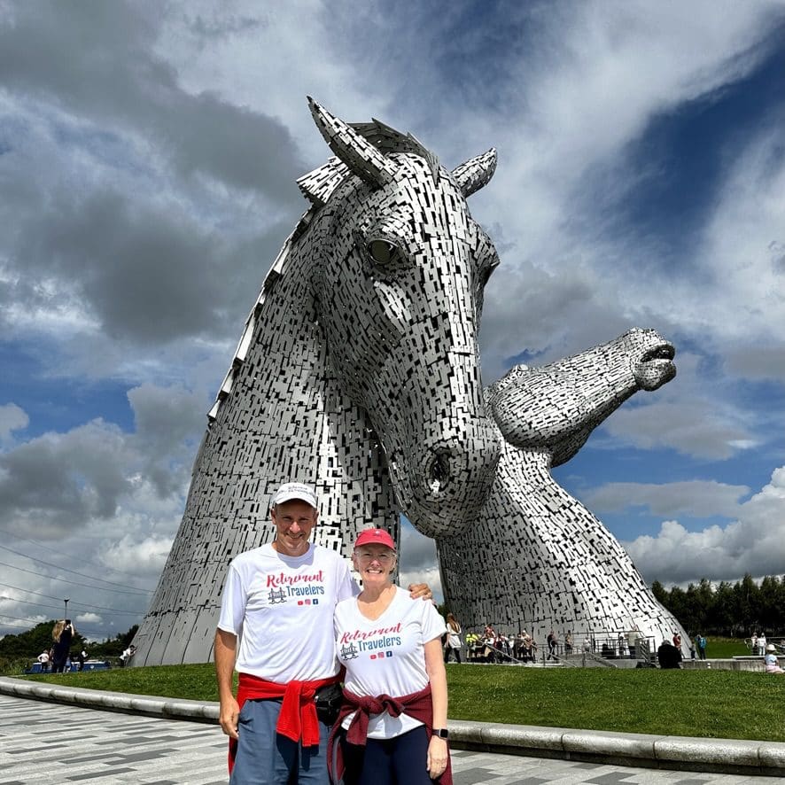 John and Bev of the Retirement Travelers standing near the Kelpies in Falkirk, Scotland