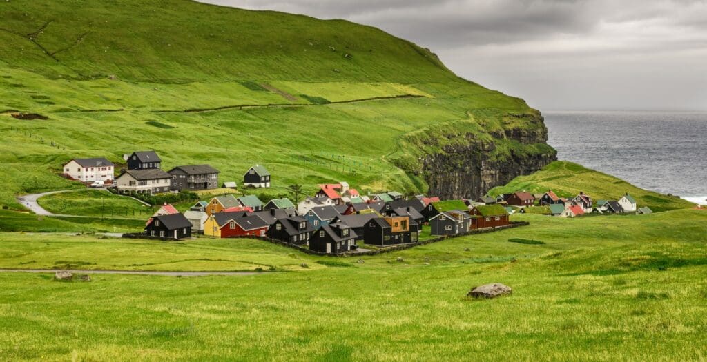 Cliffside village with green grass in the Faroe Islands