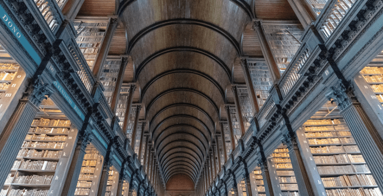 Thousands of books in an historic library with arched ceilings