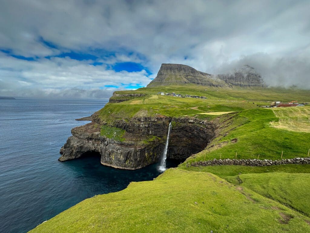 view of cliffs and Mulafossur waterfall on the Faroe Islands