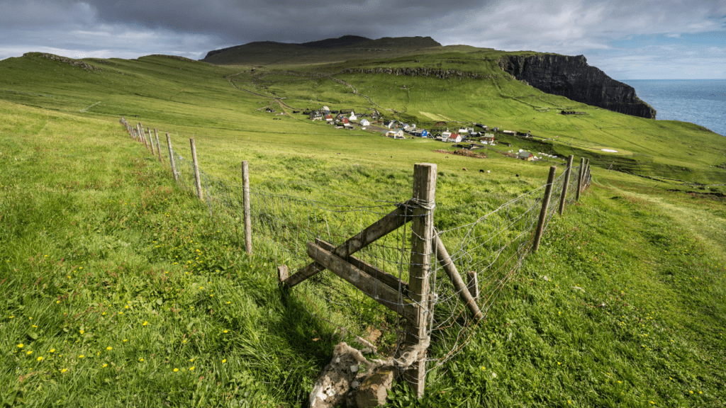 dramatic landscape with small village and steep hills in the Faroe Islands