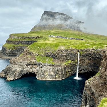 A waterfall flowing directly into the ocean on the Faroe Islands