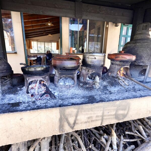 Authentic outdoor cooking in Greece where clay pots are being cooked over an open flame.