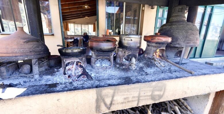 Authentic outdoor cooking in Greece where clay pots are being cooked over an open flame.