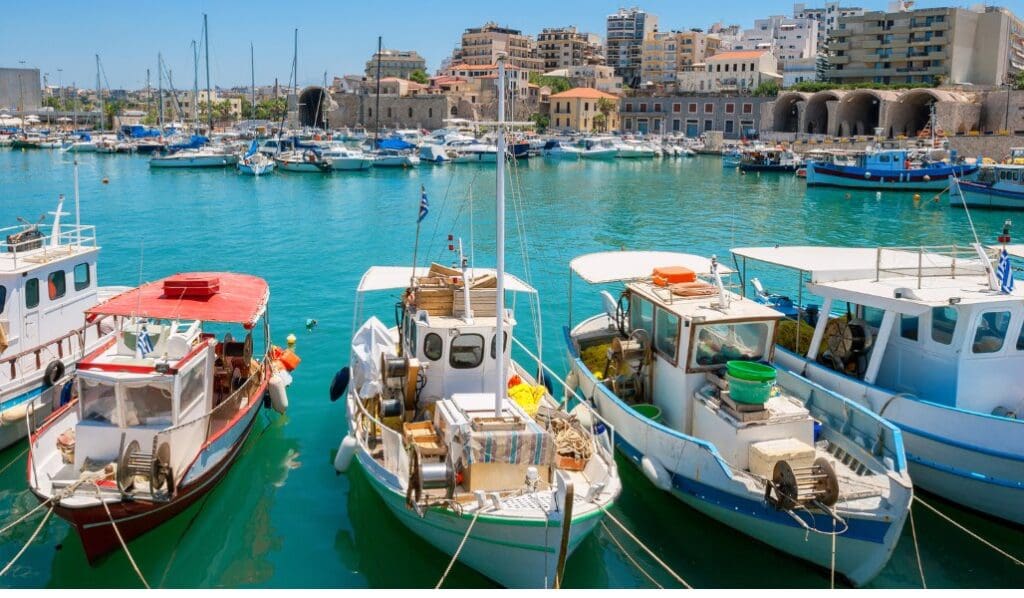 boats and turquoise water harbor in crete