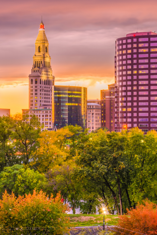 buildings at sunset in a city with trees in the foreground in Hartford Connecticut
