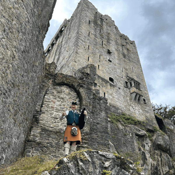 A Bagpipe player in front of the castle.