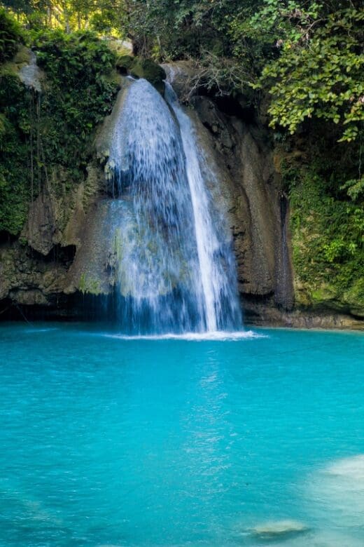 waterfall flowing into turquoise water in the Philippines