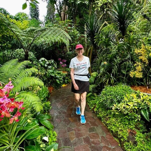 woman walking on a path in an orchid garden