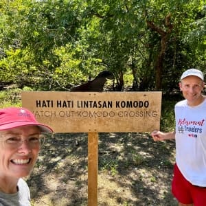 john and Bev standing by sign on komodo island