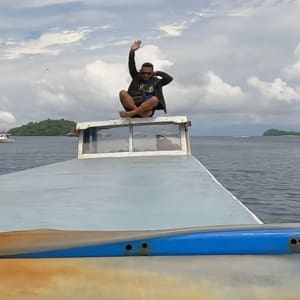 man riding on top of boat in raja ampat