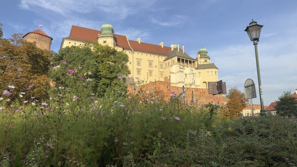 large stone castle sitting on a hill in Krakow Poland