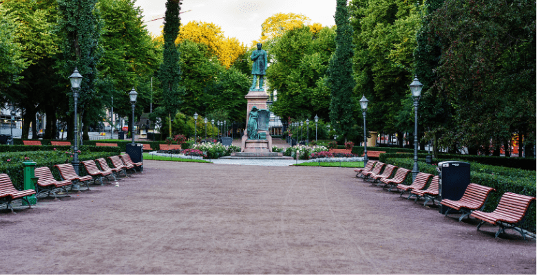 Park area in Helsinki with trees, benches, and statues