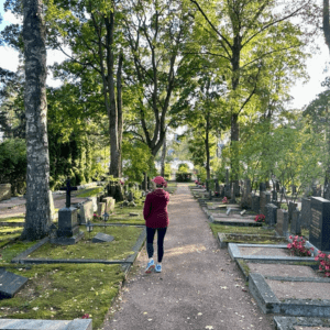 woman walking in wooded cemetery in Helsinki Finland