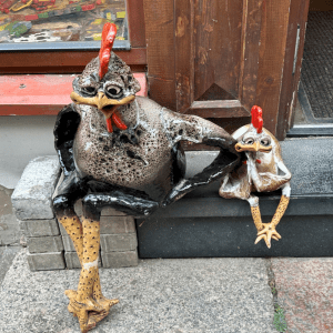 two small chicken sculptures on a step